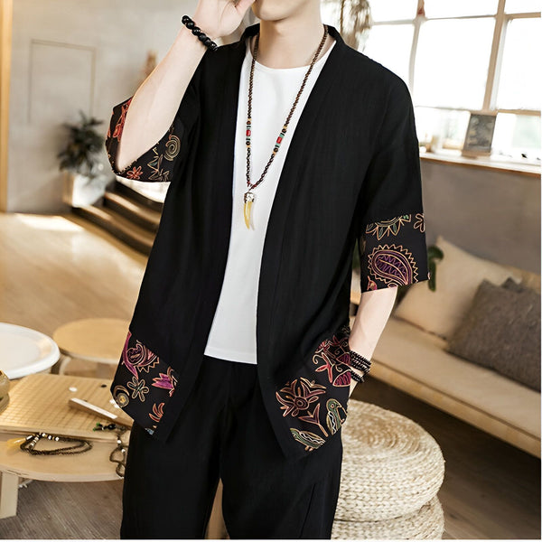 Homme portant un kimono noir avec des motifs floraux colorés sur les manches et l'ourlet. Vêtements traditionnels japonais en vente.