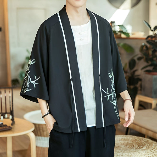 Homme portant un kimono noir avec broderies de bambou et bordures blanches. Vêtements de style japonais en vente.