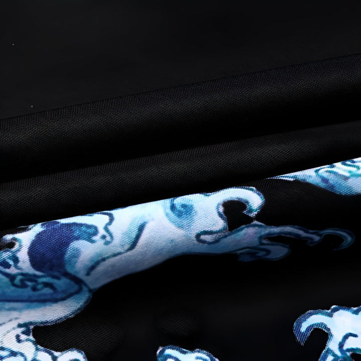 Gros plan sur le tissu d'un kimono noir avec des motifs de vagues bleues. Texture détaillée et élégante, parfaite pour un look japonais authentique. Découvrez notre collection de kimonos uniques!
