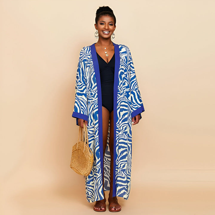 Femme portant un kimono long bleu et blanc à motifs zébrés. Kimono d'été élégant, idéal pour la plage. Vêtements de plage, peignoirs et kimonos pour femmes. Boutique de kimonos en ligne.