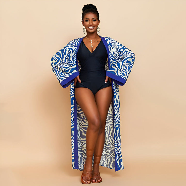Femme portant un kimono long bleu et blanc à motifs zébrés. Peignoir kimono idéal pour la plage ou la piscine. Vêtements kimono tendance.
