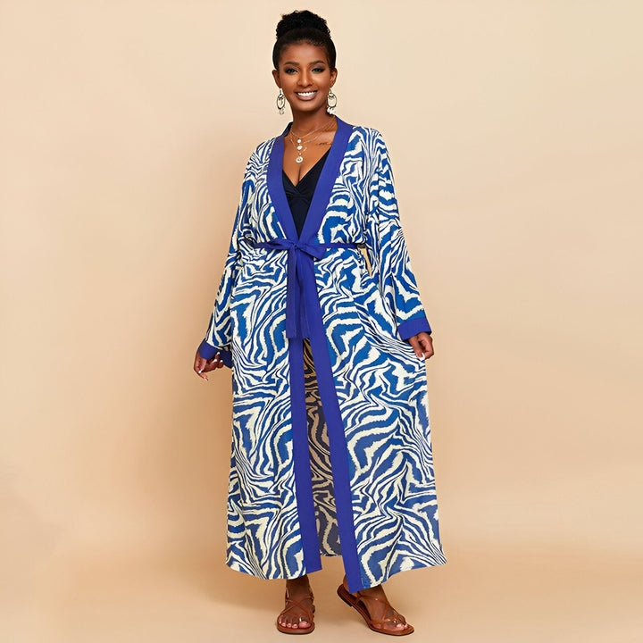 Femme souriante portant un kimono long bleu et blanc à motifs zébrés, noué à la taille. Vente de kimonos en ligne.
