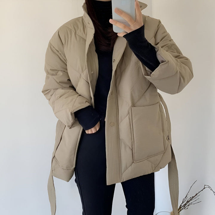 Femme portant un kimono matelassé beige, col montant noir. Style décontracté, ceinture assortie. Notre collection de kimonos.