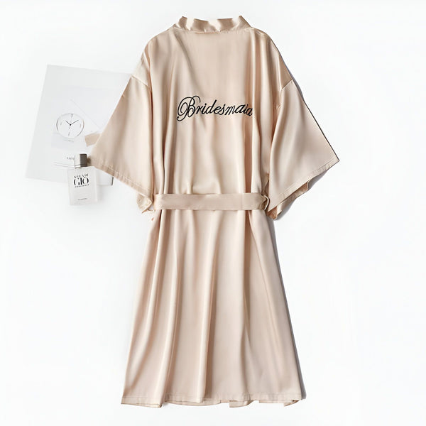 Kimono beige avec l'inscription "Bridesmaid" brodée. Peignoir soyeux pour demoiselle d'honneur, vêtement d'intérieur confortable et élégant. Idéal comme cadeau ou pour se préparer le jour du mariage.