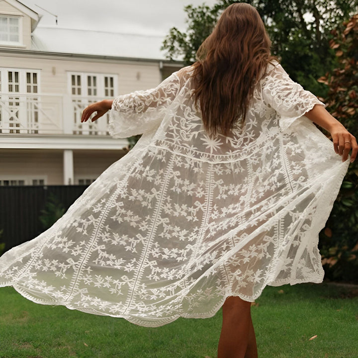 Femme portant un kimono blanc en dentelle avec des motifs floraux. Kimono léger et élégant, parfait pour l'été. Vêtements de style kimono à la mode.