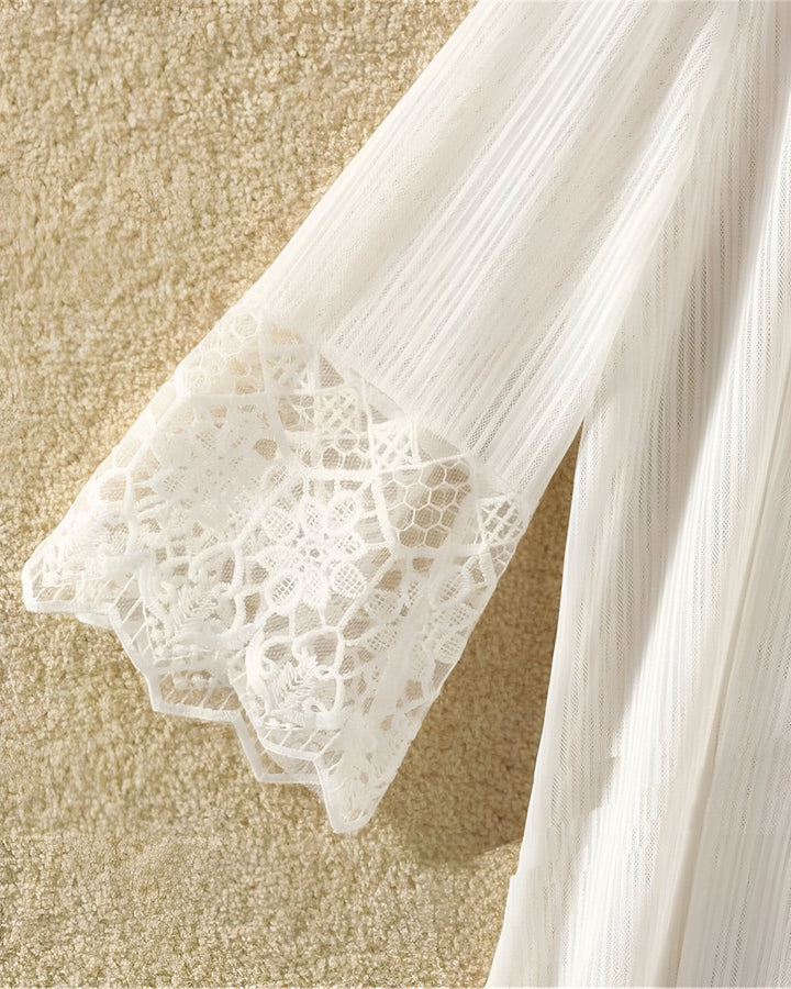 Détail d'un kimono blanc avec manches en dentelle délicate. Vêtement léger, idéal pour compléter une tenue avec élégance. Découvrez notre collection de kimonos uniques.