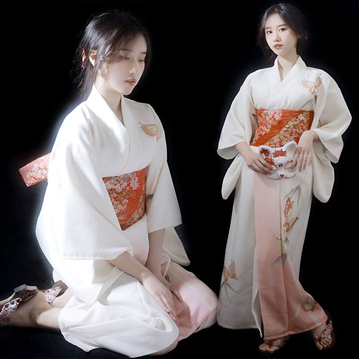 Deux femmes portant des kimonos blancs traditionnels avec des motifs floraux et des ceintures obi orange. L'une tient un masque de renard. Kimonos japonais élégants à vendre.