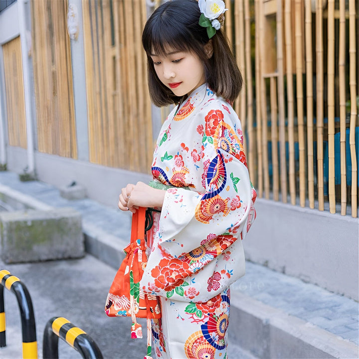 Jeune femme asiatique portant un kimono blanc à motifs floraux colorés. Vente de kimonos traditionnels et modernes. Accessoires pour kimonos disponibles.