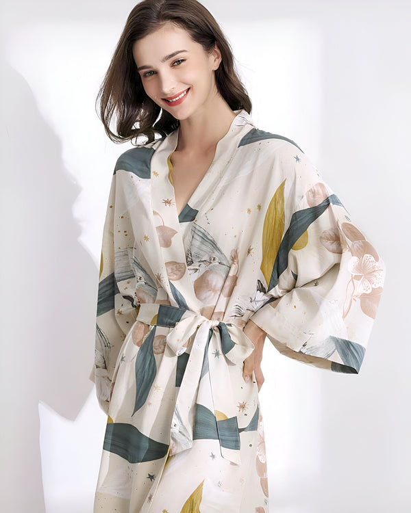 Femme souriante portant un kimono imprimé fleuri. Peignoir de style japonais avec ceinture. Vêtements d'intérieur confortables et élégants. Achetez nos kimonos uniques en ligne.