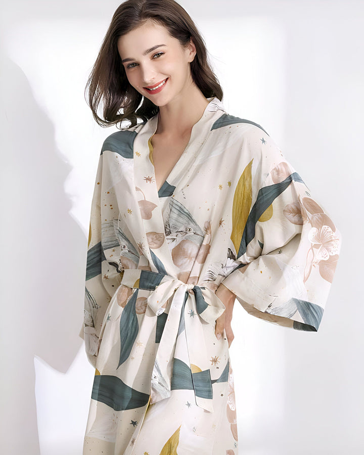 Femme souriante portant un kimono imprimé fleuri. Peignoir de style japonais avec ceinture. Vêtements d'intérieur confortables et élégants. Achetez nos kimonos uniques en ligne.