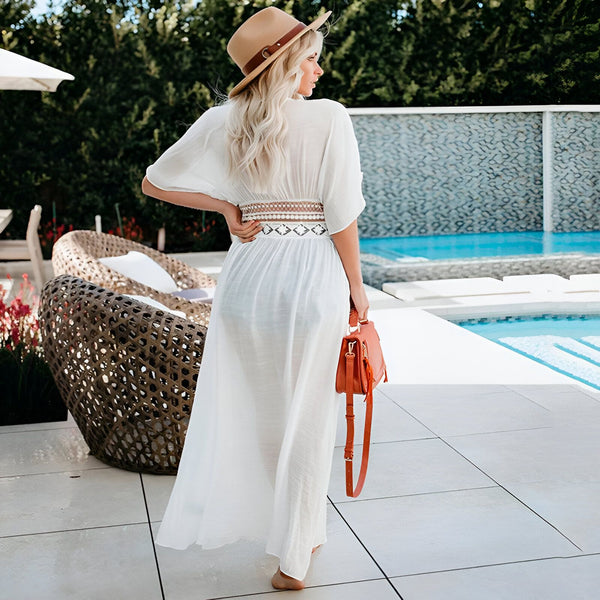 Femme portant un kimono blanc près d'une piscine. Kimono long et léger avec ceinture décorative. Accessoires : chapeau de paille et sac à main orange. Collection de kimonos pour femmes.