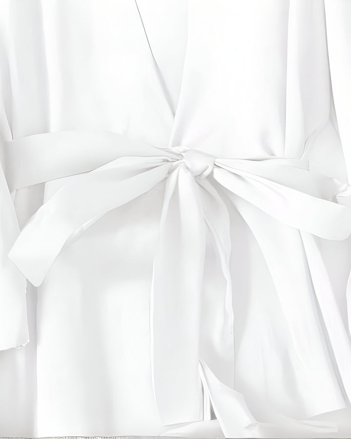 Détail d'un kimono blanc avec une ceinture nouée. Texture soyeuse et élégante. Découvrez notre collection de kimonos raffinés.