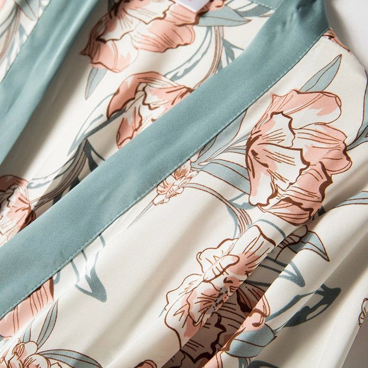 Détail d'un kimono fleuri : motif floral rose et bleu sur fond clair, avec bordure bleu clair. Vêtements de style japonais.