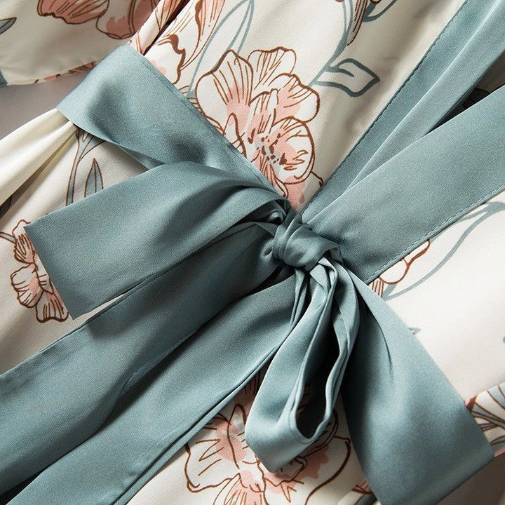 Détail d'un kimono fleuri avec ceinture en satin bleu. Kimono pour femmes disponible à l'achat. Motifs floraux délicats. Textile de qualité.