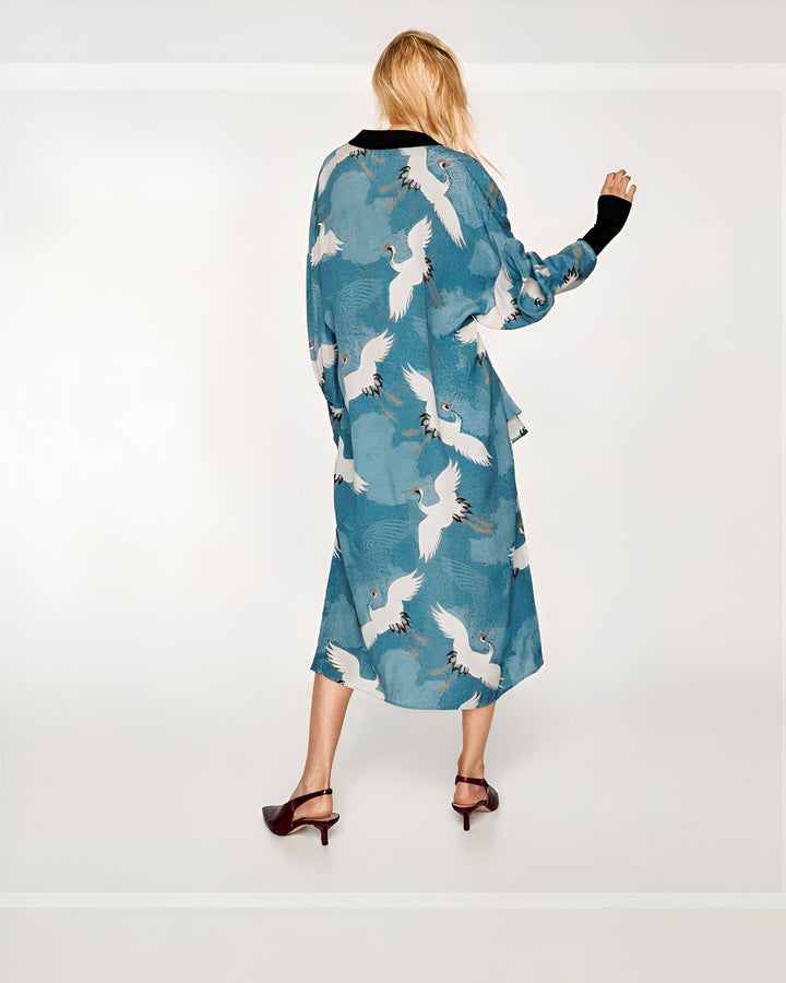 Kimono long bleu à motifs de grues blanches. Dos d'une femme portant ce kimono tendance et élégant. Vêtements de style japonais pour femme.