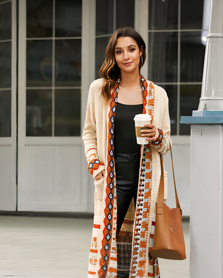 Femme portant un kimono long à motifs ethniques, tenant un café. Mode kimono tendance, idéal pour un look décontracté et stylé. Découvrez notre collection de kimonos uniques.