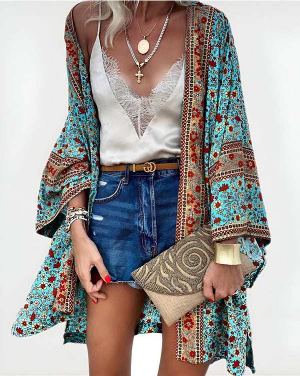 Femme portant un kimono turquoise à motifs floraux, un débardeur en dentelle, un short en jean taille haute et des bijoux dorés. Look bohème chic, idéal pour un style estival décontracté. Accessoires : pochette beige et manchette dorée.