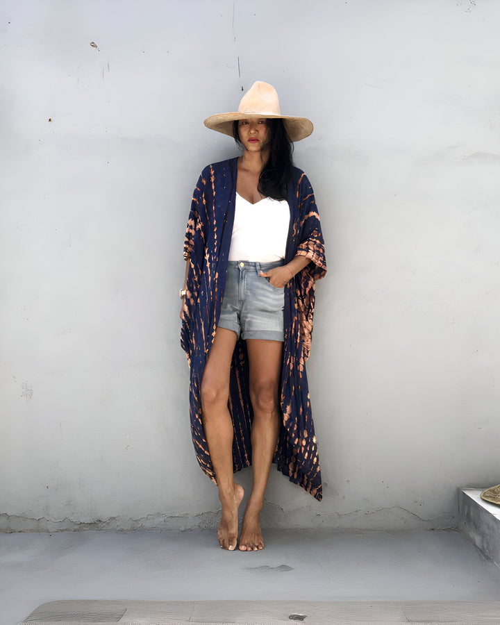 Femme portant un kimono bleu et marron, un short en jean et un chapeau. Vêtements décontractés, style bohème. Notre collection de kimonos uniques.