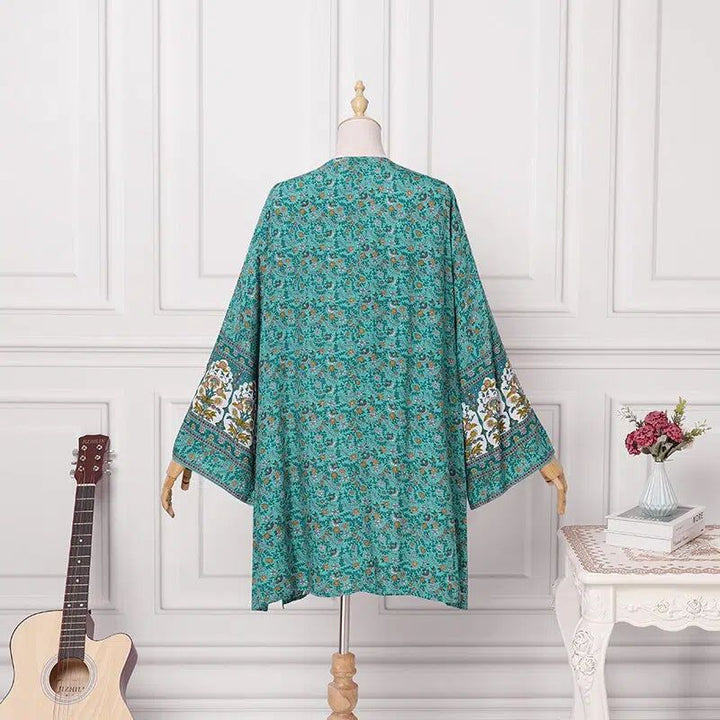 Kimono turquoise à motifs floraux sur mannequin. Vêtement ample avec manches larges. Style bohème chic.