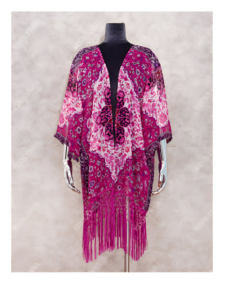 Kimono magenta à motifs floraux et franges, présenté sur mannequin. Vêtement léger et tendance, idéal pour superposer à vos tenues. Découvrez notre collection de kimonos uniques.