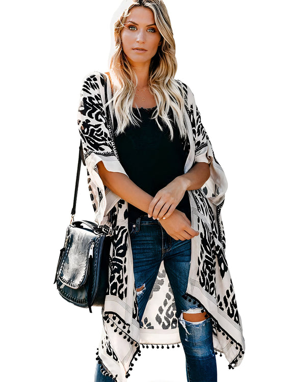 Femme portant un kimono à motifs noir et blanc, avec un jean déchiré et un sac. Kimonos élégants pour toutes les occasions. Découvrez notre collection de kimonos tendance.