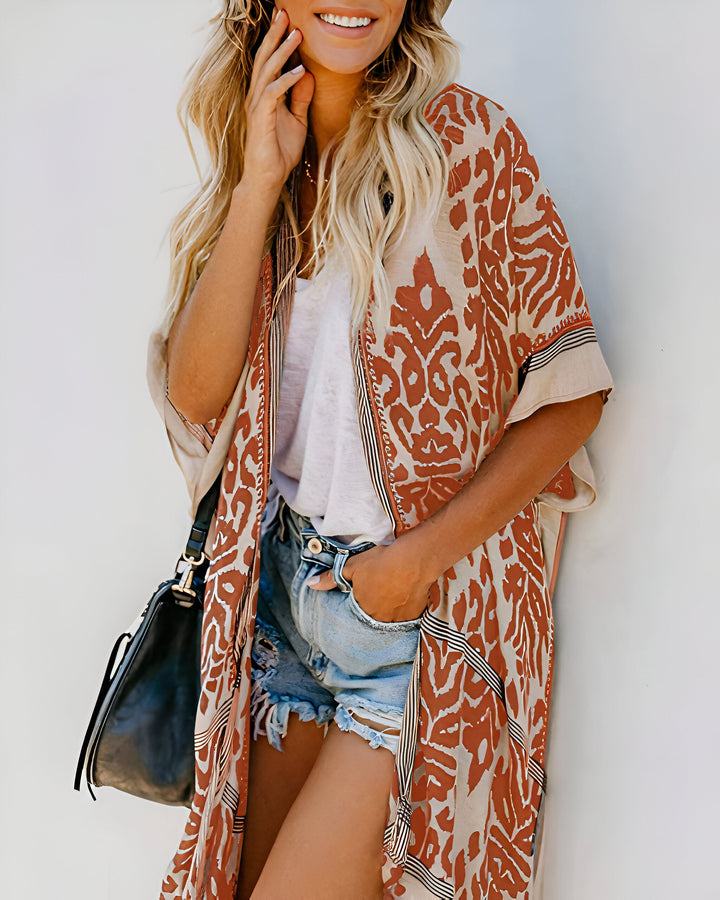 Femme souriante portant un kimono à motifs marron et beige, un short en jean et un sac noir. Vêtements kimono élégants et confortables pour toutes les occasions. Découvrez notre collection de kimonos uniques!