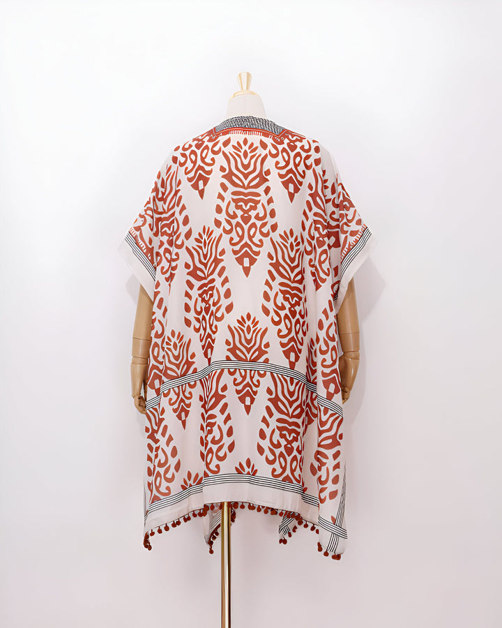 Kimono à motifs orangés, vue de dos. Vêtement ample avec pompons décoratifs. Collection de kimonos élégants.