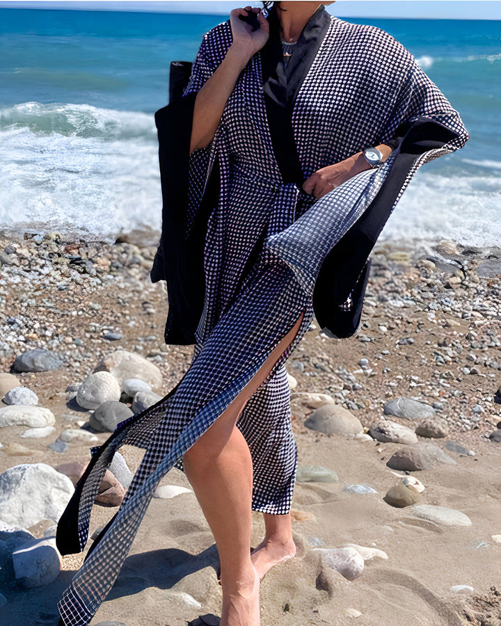 Femme portant un kimono à carreaux sur la plage, avec l'océan en arrière-plan. Kimonos élégants disponibles à l'achat. Mode kimono, vêtements de plage, style estival.