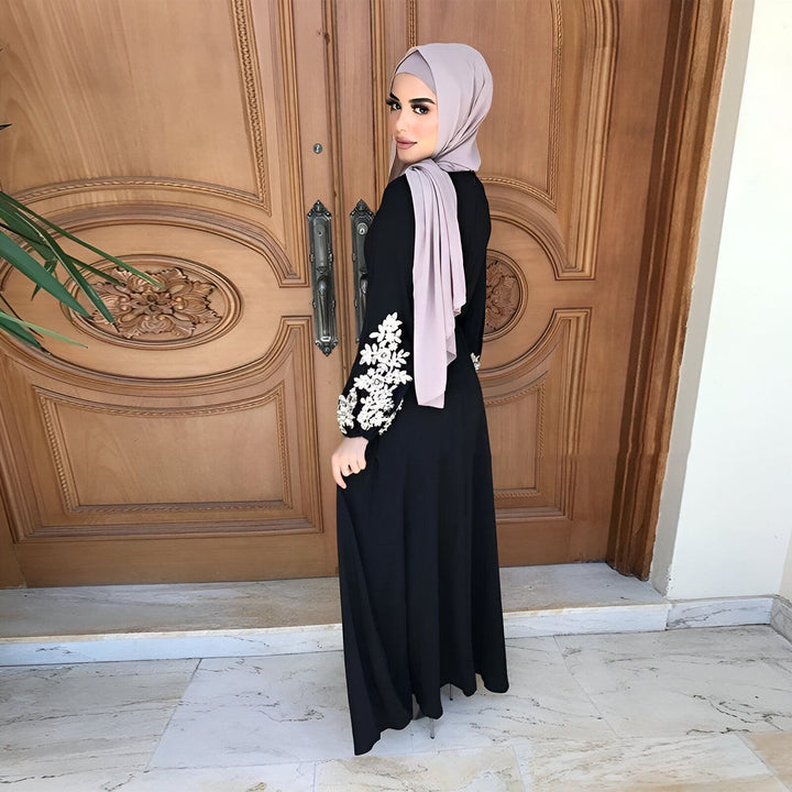 Femme portant un kimono noir brodé à manches longues et un hijab beige. Vente de kimonos élégants et modernes.