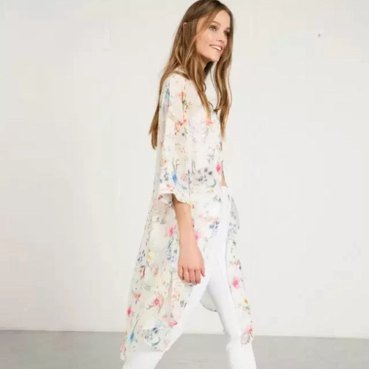 Femme portant un kimono floral léger. Vente de kimonos imprimés pour femme. Kimono blanc à motifs floraux colorés. Idée cadeau pour un look tendance et confortable.