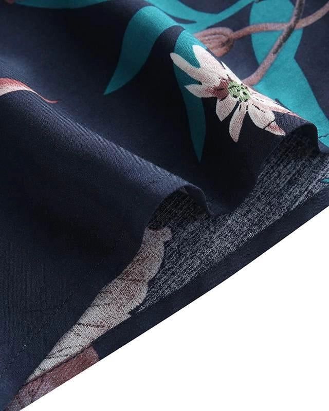 Gros plan d'un tissu de kimono bleu marine avec motif floral et feuilles turquoises. Détail de la texture et des coutures. Kimonos à motifs floraux disponibles.