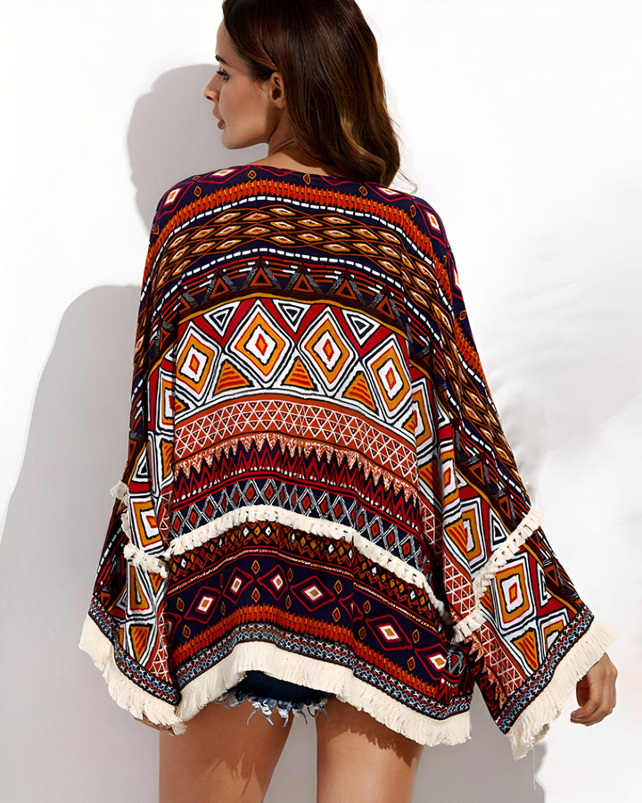 Kimono multicolore à motifs géométriques et franges. Vêtement ample et léger, idéal pour compléter une tenue estivale. Découvrez notre collection de kimonos uniques.