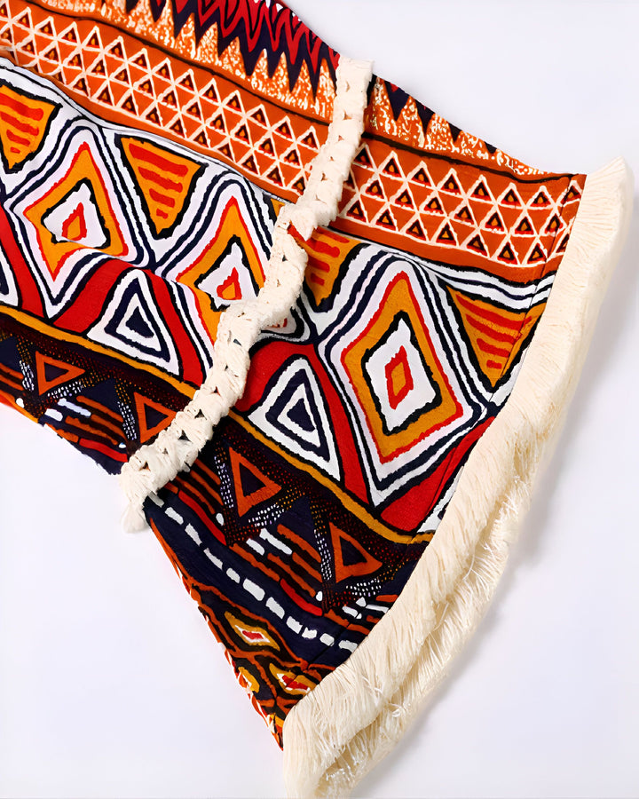 Détail d'un kimono avec motifs géométriques colorés et franges. Kimono à motifs ethniques, idéal pour un look bohème. Vêtements style kimono à motifs, disponible dans notre boutique en ligne.