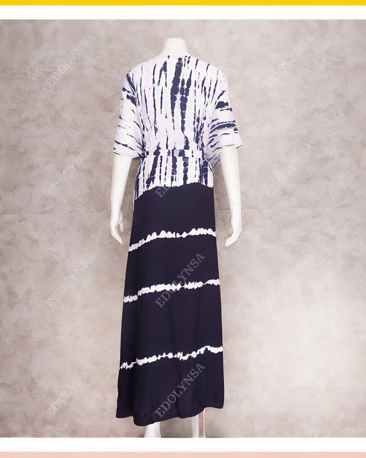 Vue arrière d'une longue robe tie-dye bleu marine et blanche sur un mannequin. La robe a une ceinture à la taille et des manches courtes amples.