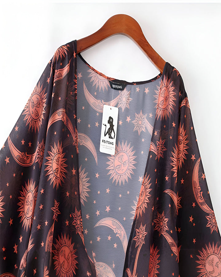 Kimono noir transparent avec motifs de soleils, lunes et étoiles orange. Vêtement léger d'été, idéal pour la plage ou une tenue décontractée.