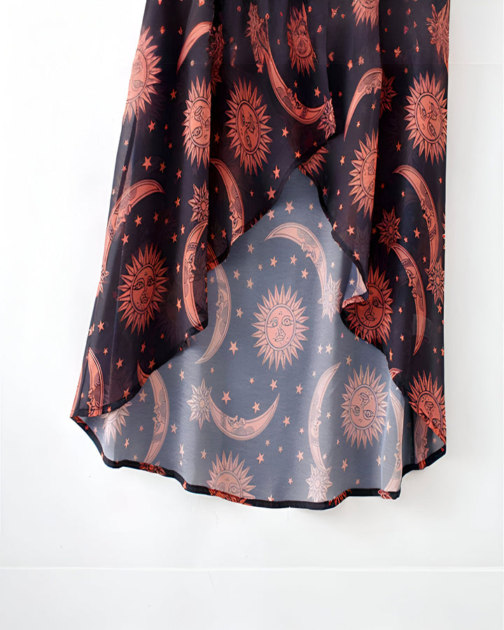 Kimono noir transparent avec motifs soleils, lunes et étoiles orange. Vêtement fluide, parfait pour superposer. Découvrez notre collection de kimonos uniques.