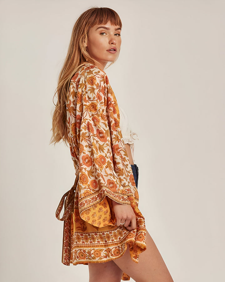 Femme portant un kimono fleuri orange et blanc. Vêtement de style japonais. Idée cadeau kimono. Boutique de kimonos en ligne.