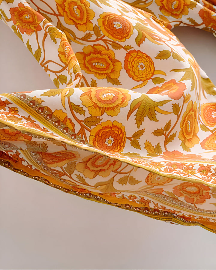 Motif floral orange et jaune sur tissu de kimono blanc. Détail d'un kimono avec des fleurs stylisées. Texture et design de tissu pour kimono. Vêtements traditionnels japonais revisités.