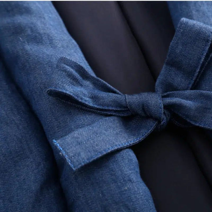 Détail d'un kimono en denim avec une ceinture nouée. Texture du tissu denim bleu. Mode japonaise, vêtement traditionnel. Kimonos en vente.