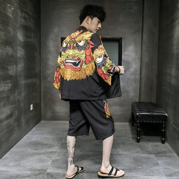 Homme portant un kimono noir avec un imprimé de lion coloré, faisant partie d'un ensemble short assorti. Vêtements japonais traditionnels revisités avec une touche moderne. Kimonos et ensembles de kimono disponibles à l'achat.