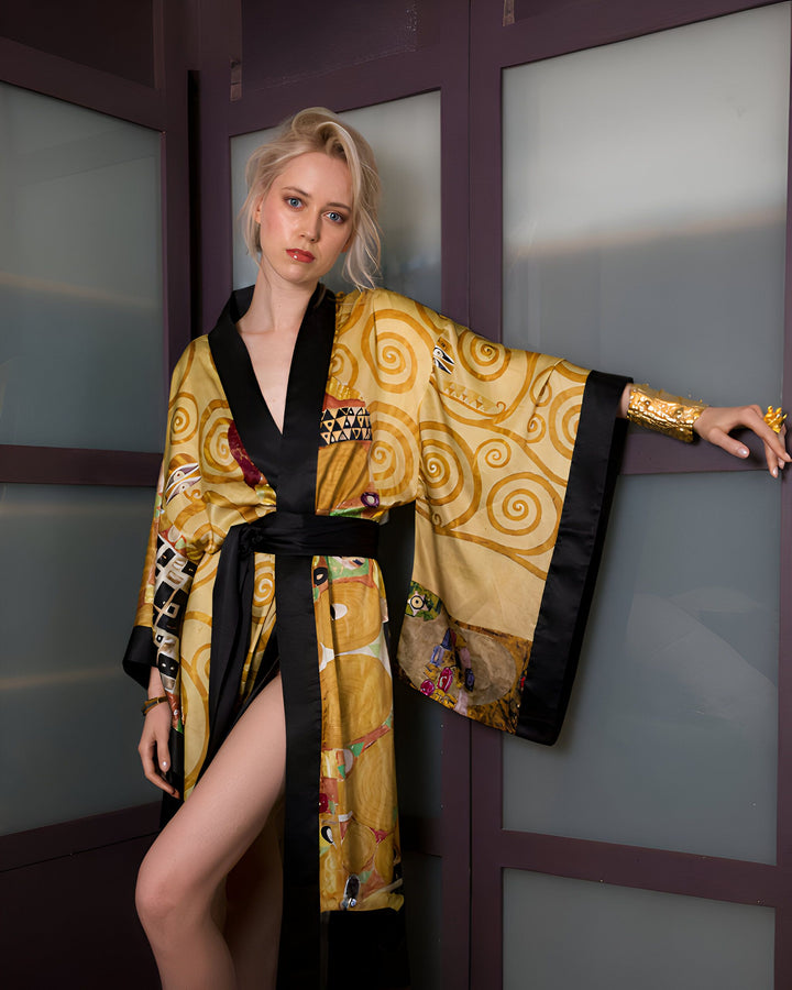 Femme blonde portant un kimono doré avec des motifs d'art abstrait et une ceinture noire. Elle porte un bracelet doré. Fond de portes violettes modernes.