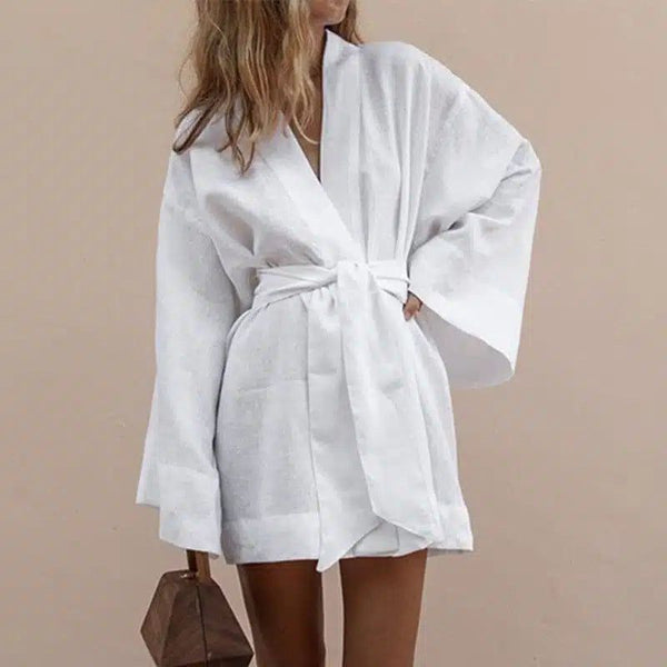 Femme portant un kimono blanc court avec une ceinture nouée. Kimono élégant et confortable, parfait pour la détente ou une sortie décontractée. Découvrez notre collection de kimonos uniques.