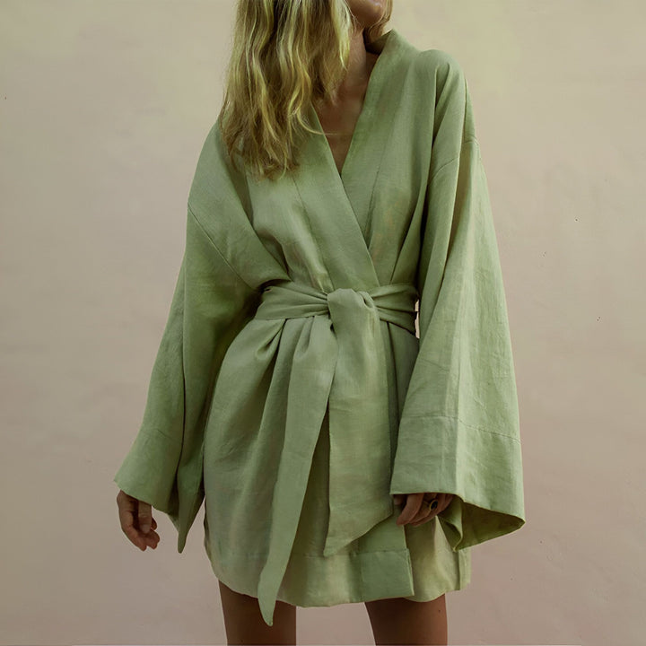 Femme portant un kimono vert en lin, noué à la taille. Vêtements japonais traditionnels revisités. Boutique de kimonos en ligne.