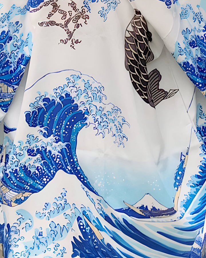 Détail d'un kimono blanc orné de motifs japonais bleus représentant une grande vague, un mont et un poisson noir. Kimono pour femme.