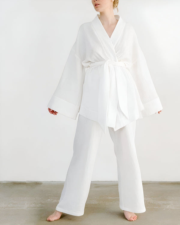 Femme portant un kimono blanc avec pantalon assorti. Ensemble kimono élégant et confortable. Vente de kimonos en ligne.