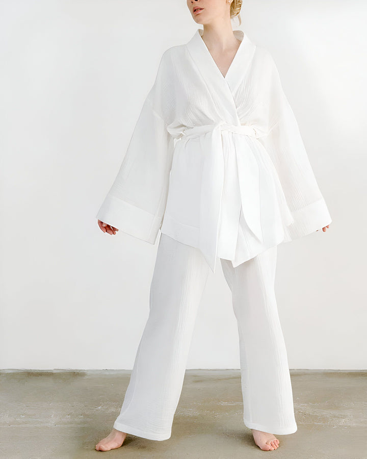Femme portant un kimono blanc avec pantalon assorti. Ensemble kimono élégant et confortable. Vente de kimonos en ligne.
