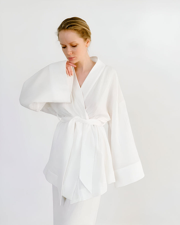 Femme portant un kimono blanc élégant. Découvrez notre collection de kimonos de haute qualité. Vêtements d'intérieur chics et confortables. Style japonais moderne.