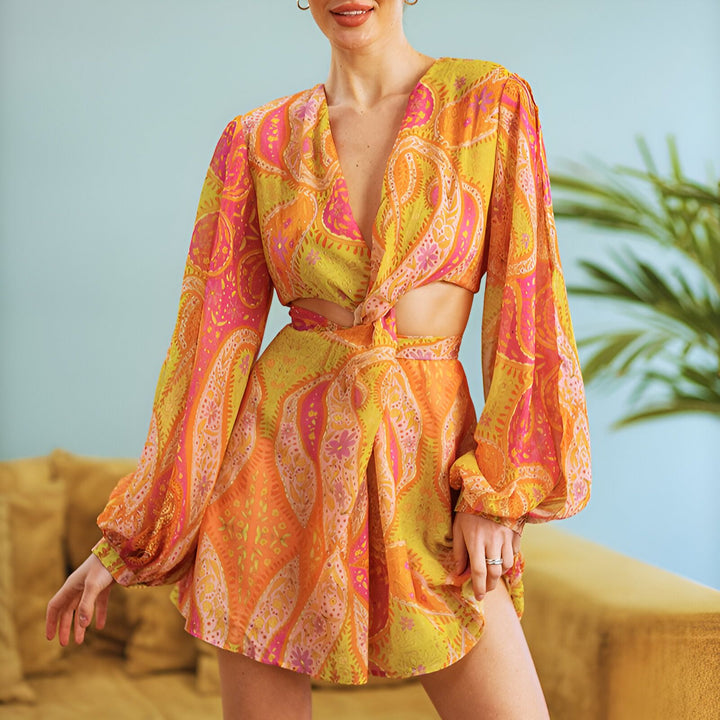 Femme portant une robe kimono courte avec un motif cachemire orange, rose et jaune. Kimono de notre collection.