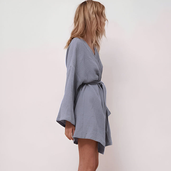 Femme portant un kimono bleu clair avec ceinture. Vêtements amples et confortables. Idéal pour la détente à la maison ou comme peignoir léger. Boutique de kimonos en ligne.