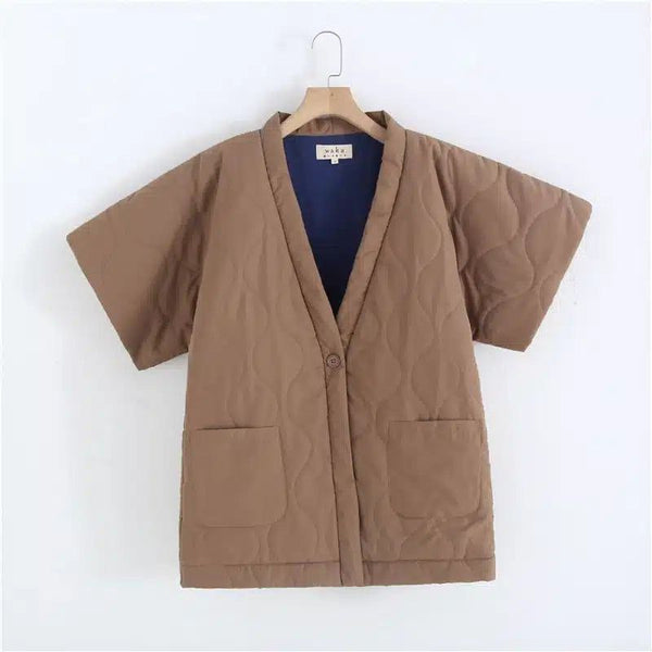 Kimono marron matelassé à manches courtes, intérieur bleu marine. Vêtement tendance avec une fermeture à bouton unique et des poches plaquées. Idéal pour un look japonais moderne.